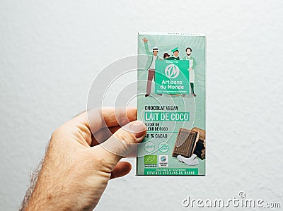Man hand holding Artisans du Monde Vegan Chocolate Editorial Stock Photo