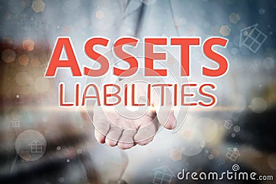 Man hand holding Assets Liabilities text on blurry home icon pro Stock Photo