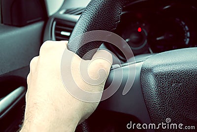 Man hand holding car steering wheel - Male hand close up shallow dof depth of field driving car - Hands on steering Stock Photo