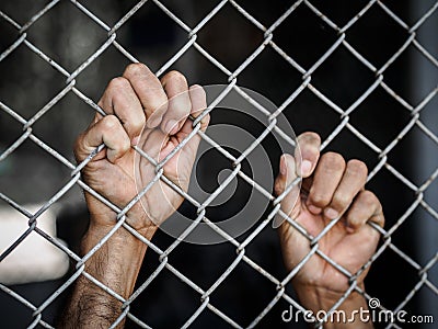 Man hand holding on chain link fence to remember Human Rights Da Stock Photo