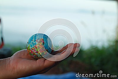 man hand holding globe on mountain earth love concept world care day Stock Photo