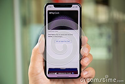 Man hand holding iPhone X with Apple Pay Cash Editorial Stock Photo