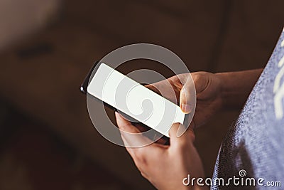 man hand holding mobile phone in coffee shop. Man using smartphone. Empty screen with copy space for text or content Stock Photo