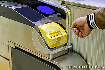 Man hand inserting ticket subway card in entrance Stock Photo