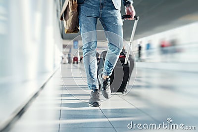 Man with hand luggage walking in airport Stock Photo