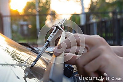 Man hand picking up car windscreen wiper..Technician changing windshield wipers blade. Mechanic check, replacing old wiper blade Stock Photo