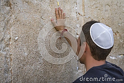 Man hand and pray paper on the Western Wall, Wailing Wall the Place of Weeping is an ancient limestone wall in the Old City of Editorial Stock Photo