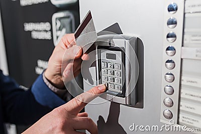 Man hand pressing the security code combination and using key card to unlock the door Stock Photo