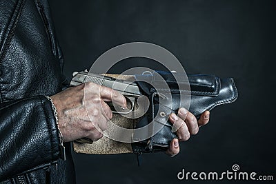 Man hand pulls a gun from a leather holster Stock Photo