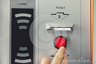 Man hand pushing red button to recieve ticket at car parking entrance. Ticket printing terminal machine with wireless card access Stock Photo