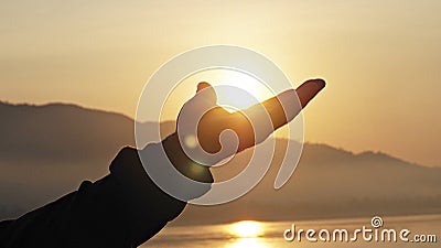 Man hand reaching to the sun in morning. Stock Photo