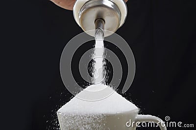 Man hand with sugar bowl pouring a crazy lot in full coffee cup in addiction concept Stock Photo