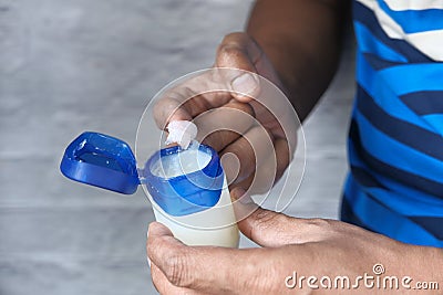 man hand use white petroleum jelly on blue background Stock Photo