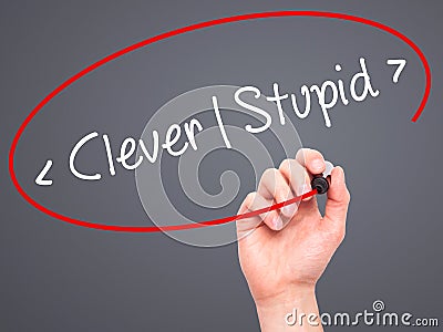 Man Hand writing Clever - Stupid with black marker on visual screen. Stock Photo