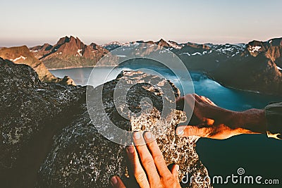Man hands climbing up to mountain summit Stock Photo