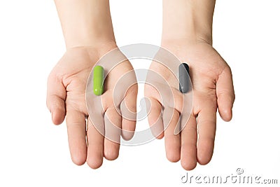 Man hands giving two big pills. Green and black. Make your selection. health or death. Choose your side Stock Photo