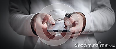 Man hands handcuffs holding smartphone. Internet and Social Media addiction Stock Photo