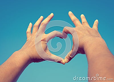 Man Hands in Heart Shape form love on Sky Stock Photo