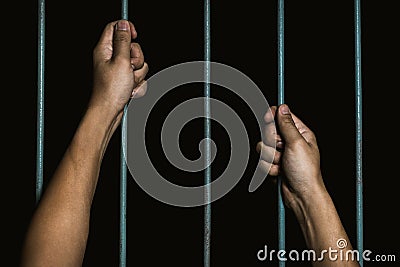 Man Hands holding iron bars in jail. Imprisoned criminal concept Stock Photo