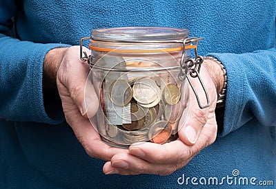Man hands holding jar full of euro money, pension fund concept, coins and banknotes Stock Photo