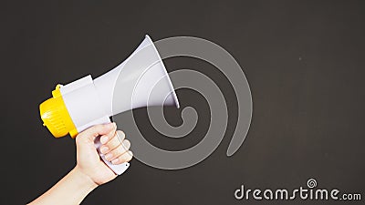 Man hands is holding yellow megaphone on black background Stock Photo