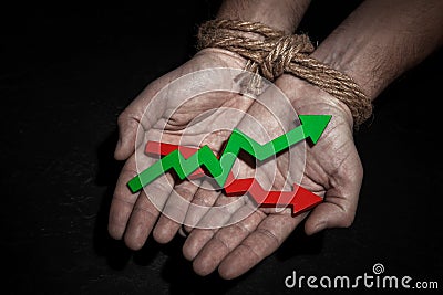 Man with hands tied with rope, in the palms of the growth arrow up green and red. Growth restraint Stock Photo