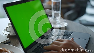 Man hands typing keyboard laptop computer green screen in cafe restaurant table. Editorial Stock Photo