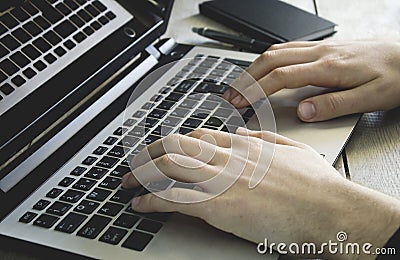 Man hands using laptop on wooden background. Stock Photo
