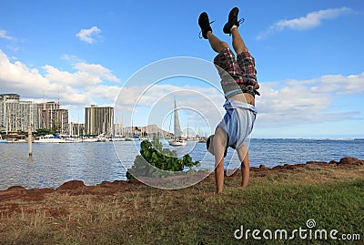 Man Handstanding along shore of Magic Island Stock Photo