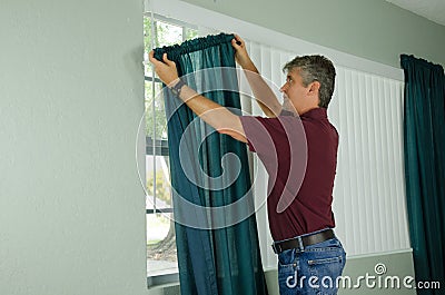 Man hanging curtains home repair maintenance Stock Photo