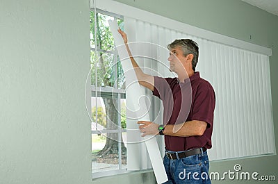 Man hanging vertical blinds home repair maintenance Stock Photo