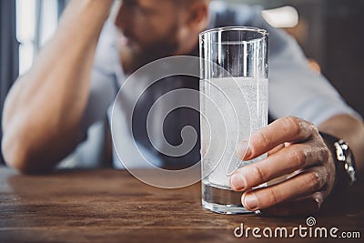 Man with hangover with medicines in messy room Stock Photo