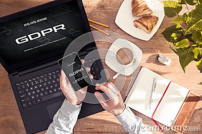 Man has `GDPR` message on his smartphone and laptop display Stock Photo