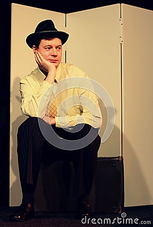 Man with Hat and Tie Sits on Suitcase Editorial Stock Photo