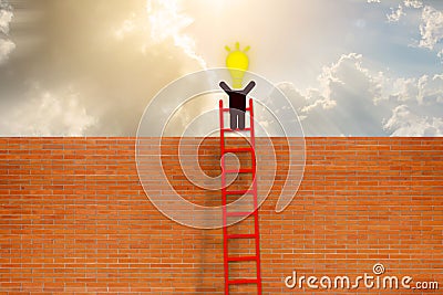 Man have idea standing on top of ladder over brick wall Stock Photo