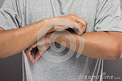 The man have problem skin, iching his arm so much. Stock Photo