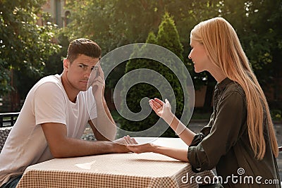 Man having boring date with talkative woman in outdoor cafe Stock Photo