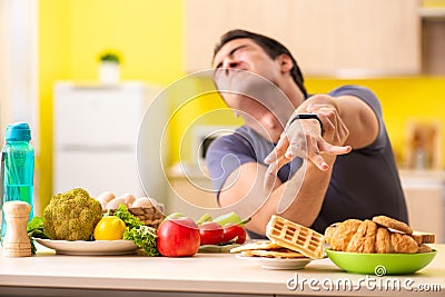 The man having hard choice between healthy and unhealthy food Stock Photo