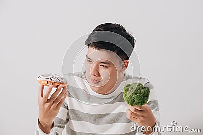 Man having hard choice between healthy and unhealthy food Stock Photo