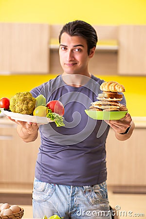 The man having hard choice between healthy and unhealthy food Stock Photo