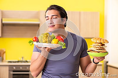 The man having hard choice between healthy and unhealthy food Stock Photo
