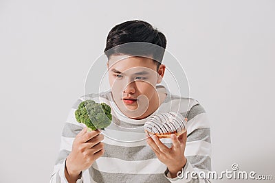 Man having hard choice between healthy and unhealthy food Stock Photo