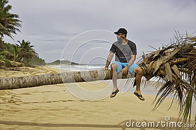 Man having a leisure time relaxing on a palm tree Stock Photo