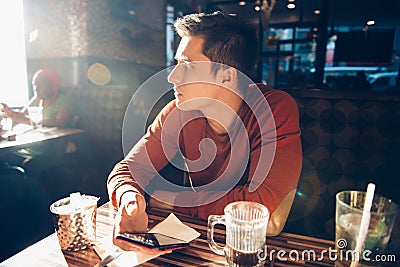 Man having morning breakfast with coffee in diner cafe and using his mobile phone. Stock Photo