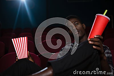 Man having popcorn and cold drink while watching movie Stock Photo