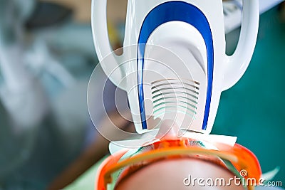 Man having teeth whitening by dental UV whitening device,dental assistant taking care of patient.Eyes protected with glasses Stock Photo