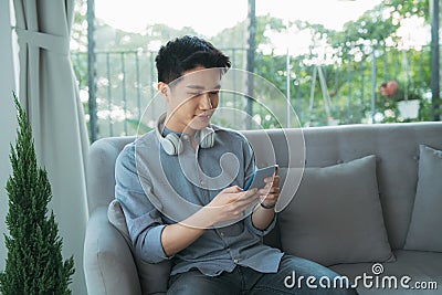 Man headphone mobile sofa game Stock Photo