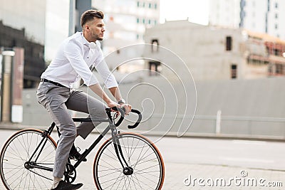 Man with headphones riding bicycle on city street Stock Photo