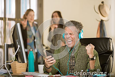 Man with Headphones Singing Loudly and Annoying Colleagues Stock Photo