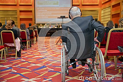 Man with headset at the conference . The audience wearing head phone for online translation . Unrecognizable people using in ear Editorial Stock Photo